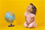 Baby and globe on the yellow background