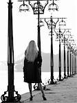 Beautiful blonde lady staying among lanterns on promenade