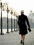 Beautiful trendy blonde lady walking over promenade