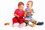 Happy toddlers playing with autumn leaves