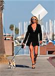 A model walks her dog on a pier