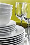 Salad, dessert, dinner plates, bowls, wine glasses against bright green background