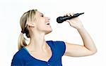 Young happy woman singing on a microphone