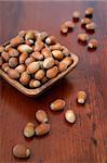 Wooden bowl with hazelnuts on a wooden table. Shallow DOF