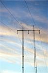 Electricity pylon against blue cloudy sky