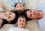 Family sleeping on the floor with heads together