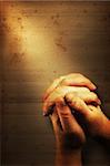 Prayers hands and sunbeam on old nostalgic background