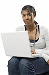 A beautiful female student sitting browsing with her laptop.