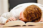 Teenage boy sleeping on his books from school