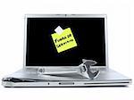 Damaged laptop with a post-it in spanish meaning Out of Service and a spanner over it. Isolated on white.