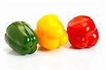 Three peppers of different colors over white background