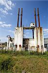 Industrial buildings decaying under a bright sky