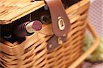 Picnic Basket, Wine Bottle and Empty Glasses on a Gingham Blanket.