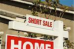 Short Sale Real Estate Sign in Front of Beautiful New Home.