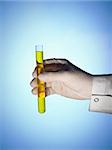 A scientist's hand holds a test tube filled with a yellow liquid over a blue background.