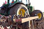 Close up of plow on a tractor in a field in spring