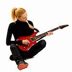 passionate rock girl playing an electric guitar sitting down