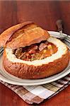 Soupe de goulasch avec saucisse de boeuf, de pommes de terre et de viande, servie dans un bol de pain