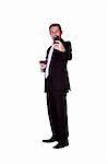 Isolated businessman celebrating with a glass of drink while sending a picture message on his cell phone