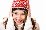 Young woman wearing a cap and a scarf with hands in her face is smiling happy. Isolated on white.