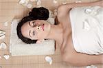 Attractive woman getting flower spa treatment in bamboo mat