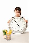 Woman at work holding up large office clock