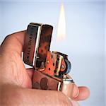 man hand in a lighter,fire on the white background.