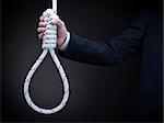 A man on a suit holds a hangman's noose over a gray background.