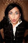 Pretty Hispanic Woman on Gold Background Making a Funny Face