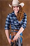 Cowgirl in studio with hat, jeans, chaps