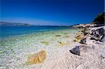 A beautiful white stone beach with clear blue water off the coast of Korcula.