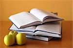 three green apples and opened books