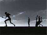 Silhouetted Zombies walking against a sky background.