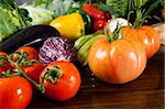 a wooden table spread of fresh vegetables