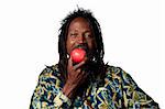 Rasta man eating an organic apple, studio shot