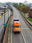 Orange lorry on the junction in city industrial zone