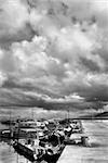 Dramatic landscape of storm scenic in harbor with boats on dock.