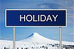 A blue road sign with white text saying Holiday