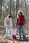 Young couple with their baby walking in the forest