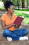 A young African American woman reading a book