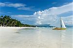 traditional paraw sailing boats on white beach on boracay island in the philippines