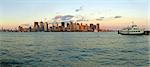 panorama photo of New York cityscape, white ferry boat in foreground, photo taken from New Jersey