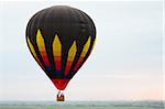 Flying hot air ballon against the sky