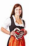 woman in love wearing Dirndl cloth holds gingerbread heart. Isolated on white background.