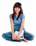 Asian student sitting on floor, with cheerful expression.