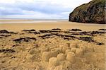 childrens sandcastles on a beach in ireland with cliffs in background