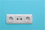Electric sockets on blue wall