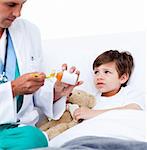 Adorable little boy taking cough medicine  in hospital
