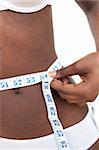 Close-up of an Afro-American woman with a tape measure against a white background