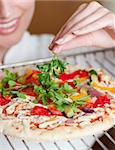 Close-up of a female chef preparing a pizza in a kitchen